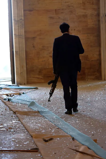 A police officer walks amid debris caused by a military helicopter bombardment inside Turkey's parliament near the Turkish military headquarters in Ankara, Turkey, Saturday, July 16, 2016. (Photo by Burhan Ozbilici/AP Photo)