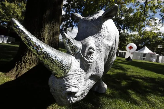 A rhinoceros sculpture with mirror-encrusted horns sits adjacent to a medical tent at the Electric Zoo music festival venue on New York's Randall's Island, Friday, August 29, 2014. (Photo by Jason DeCrow/AP Photo)