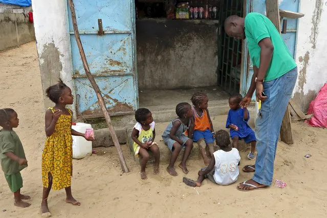 Mamadou Ka greets children near his family home after being repatriated last month from Gabon, in Dakar, Senegal, September 2, 2015. The plight of African migrants struggling to reach Europe, alongside thousands fleeing violence in the Middle East, has stirred international alarm this year, with hundreds dying at sea on the perilous Mediterranean crossing. But the majority of Africans who emigrate remain within Africa. (Photo by Makini Brice/Reuters)