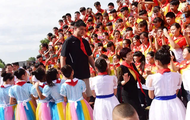 Former NBA player Yao Ming walks past participants during a donation ceremony held at a school in Weinan, Shaanxi Province, China, July 25, 2016. (Photo by Reuters/China Daily)