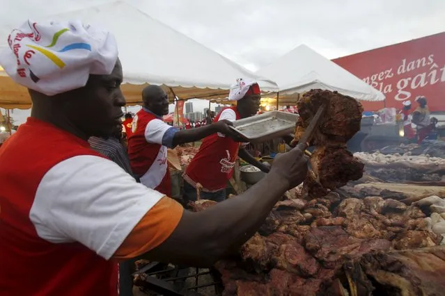 A cook sorts out grilled chicken during the Festival des Grillades, in the yard of the Culture Palace of Abidjan, September 5, 2015. The two day festival was iniated in 2008 to promote Ivorian cuisine, which revolves around grilled food. (Photo by Luc Gnago/Reuters)