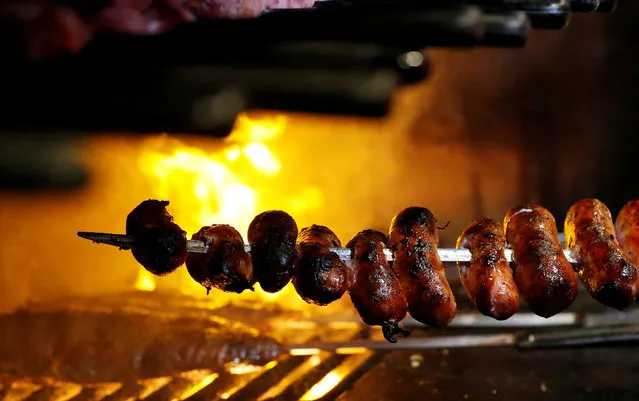 An employee grills sausages at the Braseiro restaurant in Rio de Janeiro, Brazil, July 28, 2016. (Photo by Sergio Moraes/Reuters)