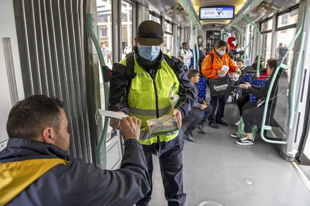 Members staff of the Transports publics genevois, TPG, (Geneva Public Transport), distribute protective face masks as a preventive mesure against the spread the coronavirus COVID-19 to passengers, in Geneva, Switzerland, 12 May 2020.  In Switzerland since 11 May, the Swiss authorities lifted second part of the lockdown. Classroom teaching at primary and lower secondary schools will again be permitted. Shops, markets, museums, libraries and restaurants reopen under strict compliance with precautionary measures as a precaution against the spread of the coronavirus COVID-19. (Photo by Salvatore Di Nolfi/EPA/EFE/Rex Features/Shutterstock)