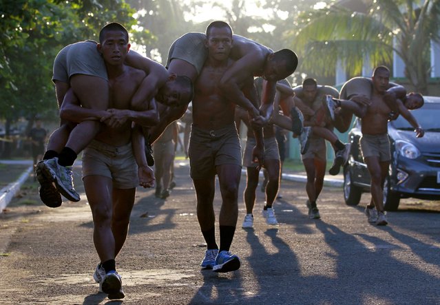 New recruits of the Philippine Navy Seals carry their colleagues during a physical training exercise at the Philippine Navy headquarters in Sangley Point, Cavite city, south of Manila September 26, 2014. (Photo by Romeo Ranoco/Reuters)