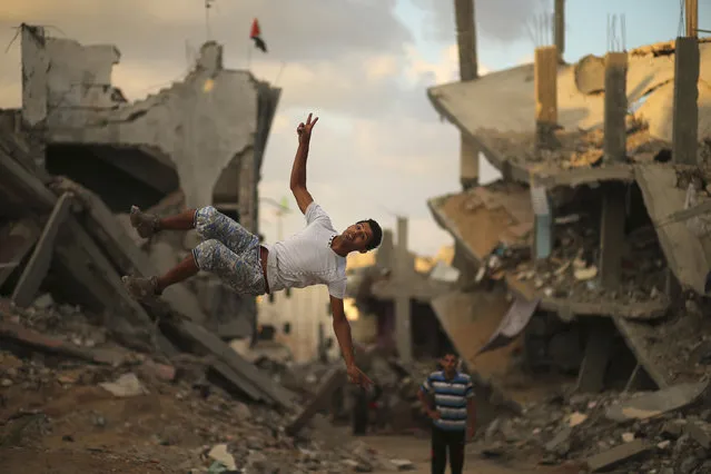 A Palestinian youth practices his Parkour skills near the ruins of houses, which witnesses said were destroyed during a seven-week Israeli offensive, in the Shejaia neighborhood east of Gaza City October 1, 2014. (Photo by Mohammed Salem/Reuters)