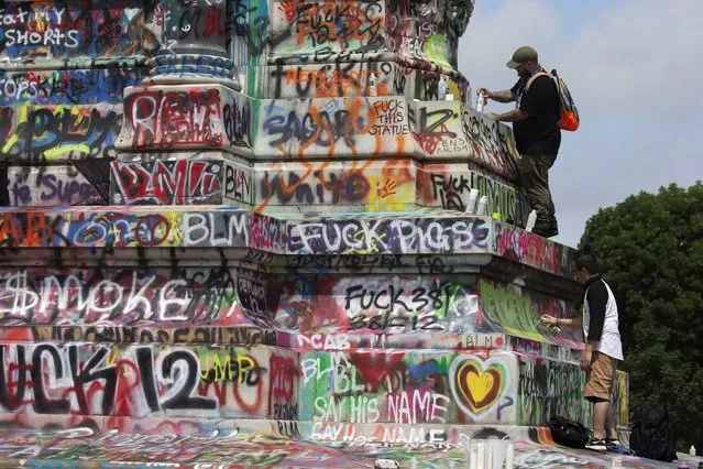 Supporters of Black Lives Matter (BLM) paint graffiti on the base of the statue of Confederate general Robert E. Lee in Richmond, Virginia, USA, 20 June 2020. Following the death of George Floyd while in Minneapolis police custody protests of outrage have resulted in the removal of Confederate memorials in many parts of the country. Virginia Governor Ralph Northam's order for the removal of the statue of Confederate general Robert E. Lee is under an indefinite injuction due to a jugde's order. Removal of the statue has been demanded by Black Lives Matter supporters but opposed by conservative second amendment advocacy groups such as “The Right to Bear Arms Virginia”. (Photo by Michael Reynolds/EPA/EFE)
