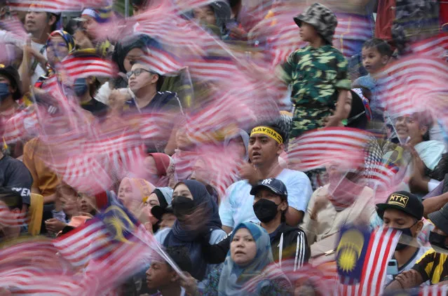 Malaysians wave their national flag during the National Day 2022 celebration at Kuala Lumpur, Malaysia on August 31, 2022. (Photo by Hasnoor Hussain/Reuters)