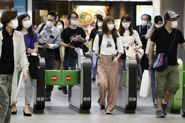 Passengers wearing face masks to protect against the spread of the new coronavirus pass the gates at Yokohama station Tuesday, July 14, 2020. (Photo by Koji Sasahara/AP Photo)