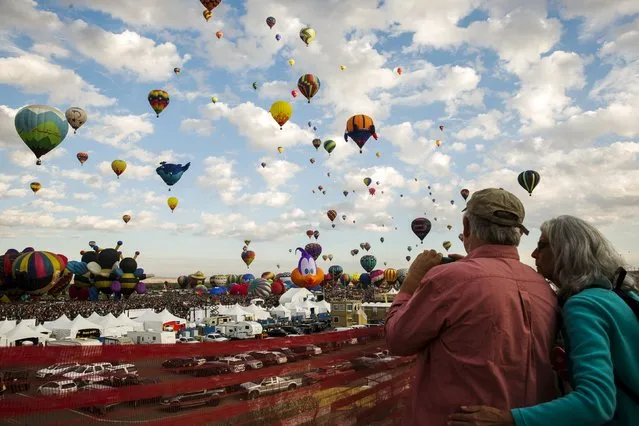 Attendees watch as hundreds of hot air balloons lift off on the first day of the 2015 Albuquerque International Balloon Fiesta in Albuquerque, New Mexico, October 3, 2015. (Photo by Lucas Jackson/Reuters)
