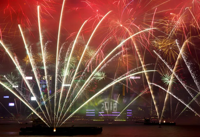 Fireworks explode over the Victoria Harbor during New Year's Eve to celebrate the start of year 2018 in Hong Kong, Monday, January 1, 2018. (Photo by Kin Cheung/AP Photo)