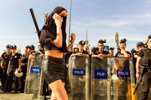 Forrest Walker, “Police Walk”. Walker describes this shot, taken in 2015 at the last officially permitted Pride parade in Istanbul, as a tense and surreal experience. His focus is on a woman walking calmly in front of a line of riot police, her attitude part defiance and part performance. (Photo by Forrest Walker/All About Photo awards 2025 via The Guardian)