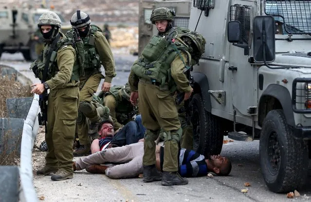 Israeli soldiers detain wounded Palestinian protesters during clashes near the Jewish settlement of Bet El, near the West Bank city of Ramallah October 7, 2015. (Photo by Mohamad Torokman/Reuters)