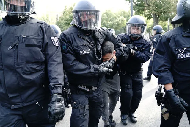 The police take vegan chef Attila Hildmann into custody during a demonstration against COVID-19 measures, in Berlin, Germany, Saturday, August 29, 2020. Berlin police ordered a protest by people opposed to Germany’s pandemic restrictions to disband after participants refused to observe social distancing rules. Tens of thousands of people had gathered at the  Brandenburg Gate before marching through the German capital in a show of defiance Saturday against Germany's coronavirus prevention measures. (Photo by Kay Nietfeld/dpa via AP Photo)