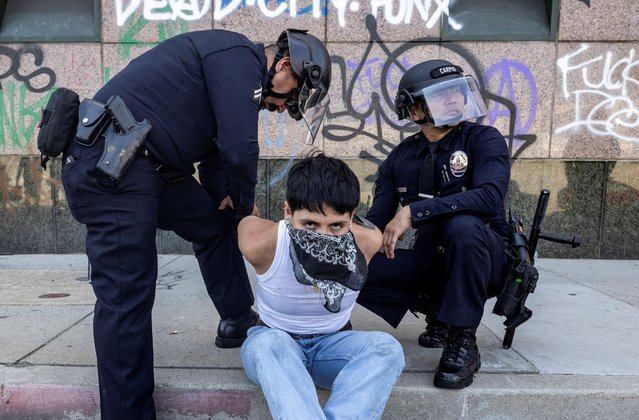 LAPD officers detain a demonstrator near the Los Angeles Detention Center during a protest against federal immigration sweeps, on June 8, 2025. (Photo by Barbara Davidson/Reuters)