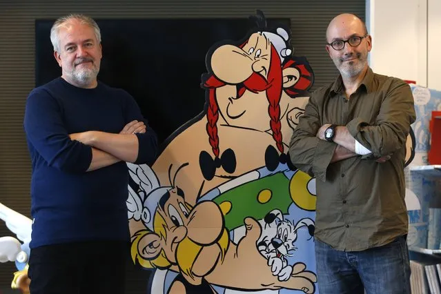 Author Jean-Yves Ferri (R) and illustrator Didier Conrad (L) pose next to cardboard cut-out of Obelix and Asterix in Vanves, near Paris, France, October 13, 2015. Ferri and Conrad wrote a new comic book "Le Papyrus de Cesar" (Asterix and the Missing Scroll), the latest in the series of comic books created by illustrator Albert Uderzo and writer Rene Goscinny in 1959 that have sold 352 million copies worldwide. (Photo by Charles Platiau/Reuters)