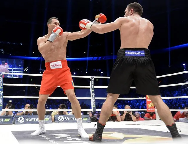 Ukrainian WBA, WBO, IBO and IBF heavyweight boxing world champion Vladimir Klitschko (L) and challenger Bulgarian heavyweight boxer Kubrat Pulev exchange punches during their title fight in Hamburg, November 15, 2014. World heavyweight champion Vladimir Klitschko knocked out Bulgarian challenger Kubrat Pulev with a fierce left hook in the fifth round on Saturday to retain his IBF title and end his opponent's unbeaten record. (Photo by Fabian Bimmer/Reuters)