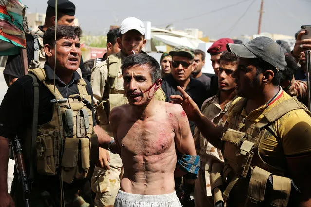 Iraqi security forces with Sunni Muslim tribal fighters arrest a member of the Islamic State in Shirqat, Iraq, September 22, 2016. (Photo by Reuters/Stringer)