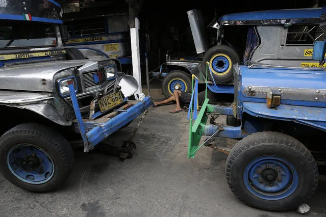 In this September 22, 2017, photo, a worker checks the suspension of a jeepney at a manufacturing plant in Manila, Philippines. Sarao Motors Inc., founded in the 1950's, is one of the oldest jeepney manufacturing companies in the country. (Photo by Aaron Favila/AP Photo)