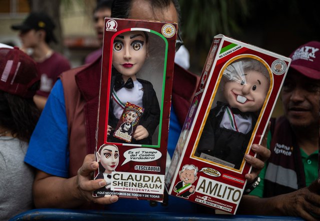 A man holds dolls bearing the image of presidential candidate Claudia Sheinbaum of the Morena party and Mexican President Andrés Manuel López Obrador as he waits for candidates to arrive for the second Presidential debate ahead of the June 2 national elections in Mexico City, on April 28, 2024. (Photo by Carl de Souza/AFP Photo)