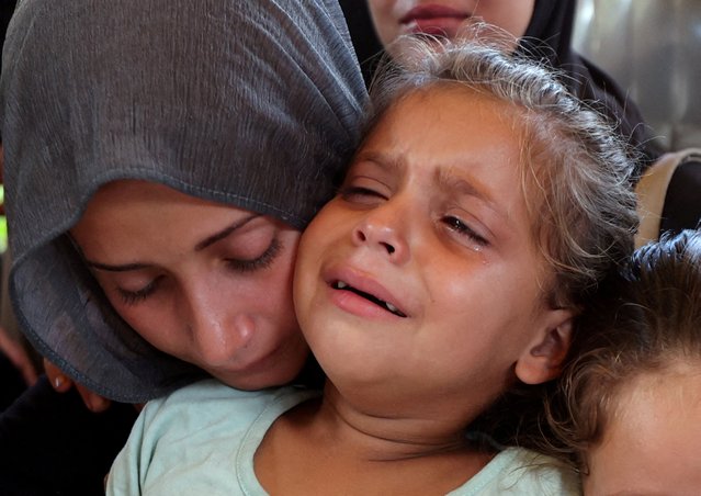 A woman and a child react during the funeral of Palestinians, who were killed by Israeli fire while trying to receive aid on Wednesday, and Palestinians who were killed in overnight Israeli airstrikes on tents, according to medics, at Nasser Hospital in Khan Younis, southern Gaza Strip on July 31, 2025. (Photo by Ramadan Abed/Reuters)
