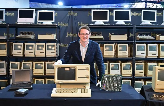 Erik Rosenblum, NFT Development Strategist at Julien's Auctions, poses behind the Apple Lisa, one of the first personal computers released in 1983 on display with motherboard at Julien's Auctions on February 22, 2023 in Gardena, California ahead of “The Apples” auction scheduled for March 10, 2023 at Julien's Auctions in Beverly Hills. A collection of nearly half a century of computers that trace the evolution of one of the world's most influential companies is going under the hammer in California next month. Aficionados of Steve Jobs' groundbreaking firm will be able to get their hands on a suite of devices that showcase how Apple became a household name. (Photo by Frederic J. Brown/AFP Photo)