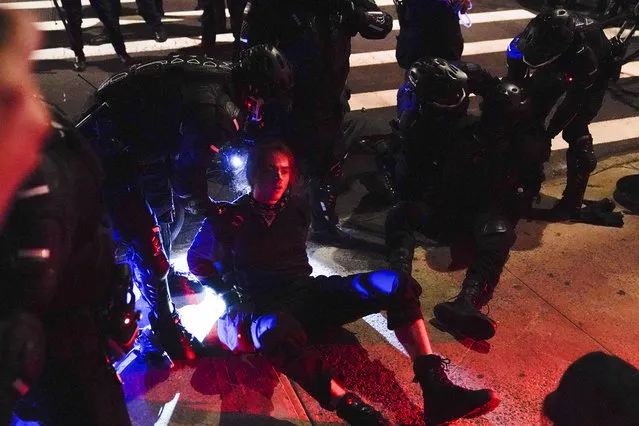 New York Police officers arrest a protestor as he marched through the East Village during demonstration, Wednesday, November 4, 2020, in New York. (Photo by Seth Wenig/AP Photo)