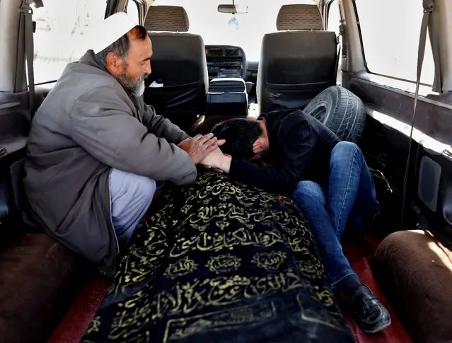 An Afghan man (R) mourns over the body of his brother who was killed in yesterday's suicide bombing, before a burial ceremony in Kabul, Afghanistan on October 25, 2020. (Photo by Mohammad Ismail/Reuters)