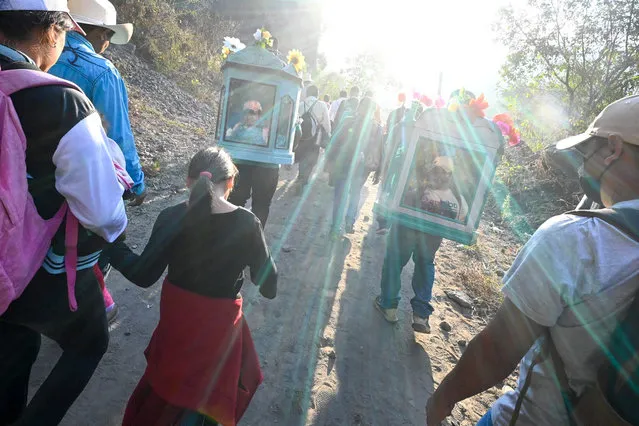 Catholics faithfuls participate in the pilgrimage of the child “Jesusito” and the child “Zarco”, on a walk of more than 25 km from the towns of San Ramon and Candelaria to San Pedro Nonualco, in San Ramon, El Salvador on February 4, 2022. As every February 4, hundreds of Salvadorans from several indigenous villages joined in pilgrimage to take two small images of the “Jesus Child” to the city of San Pedro Nonualco. From the town of San Ramon, a group of faithful departed with the urn containing the image of “Jesusito”, while from the neighboring town of Candelaria, the pilgrims did the same with the image of the “Zarco Child”, a small Jesus characterized with intense blue eyes. (Photo by Marvin Recinos/AFP Photo)