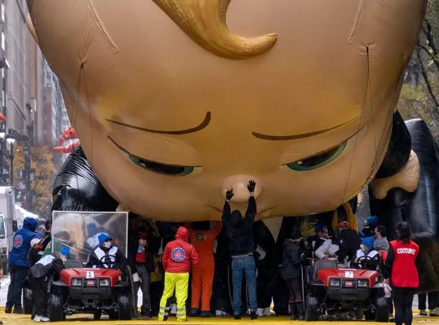 The Boss Baby balloon is deflated as it ends its appearance during the modified Macy's Thanksgiving Day Parade in New York, Thursday, November 26, 2020. The balloons were in the sky and the marching bands took to the streets for the annual Macy's Thanksgiving Day Parade on Thursday, but coronavirus restrictions meant it was without the throngs of people usually scrambling for a view. (Photo by Craig Ruttle/AP Photo)