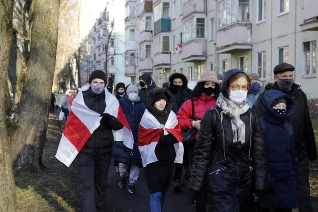 Demonstrators, most of them wearing face masks to help curb the spread of the coronavirus, attend an opposition rally to protest the official presidential election results in Minsk, Belarus, Sunday, December 6, 2020. Protests in Belarus have continued for almost four months after President Alexander Lukashenko won his sixth term in office in an election the opposition says was rigged. (Photo by AP Photo/Stringer)