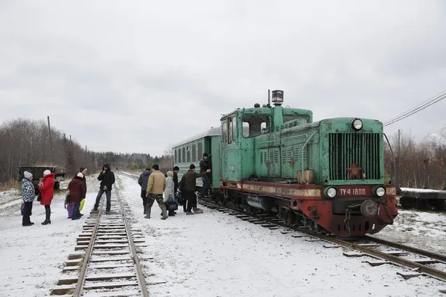 People wait to board a train in the village of Ugolnaya, in Sverdlovsk region, Russia, October 16, 2015. Many people who live along the Alapayevsk narrow-gauge railway do not earn enough to buy a car and so depend on the railway for transportation. Train tickets cost between 10 and 50 cents. (Photo by Maxim Zmeyev/Reuters)