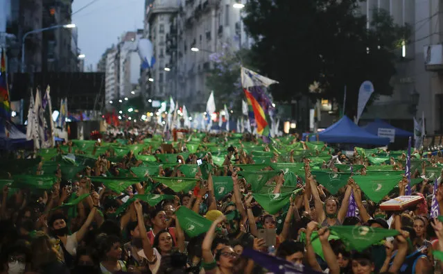 Abortion-rights activists rally outside Congress with green handkerchiefs associated with the movement to decriminalize abortion, as lawmakers debate a bill on its legalization, in Buenos Aires, Argentina, Thursday, December 10, 2020. (Photo by Natacha Pisarenko/AP Photo)