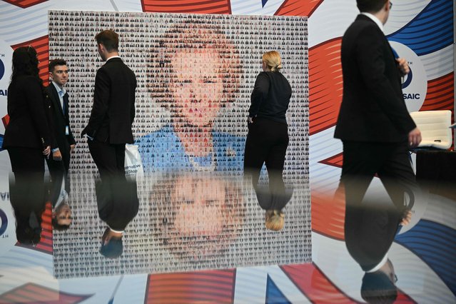 Delegates look at a montage creating an image of former Conservative prime minister Margaret Thatcher on the third day of the annual Conservative Party conference in Manchester, north-west England, on October 7, 2025.  (Photo by Oli Scarff/AFP Photo)