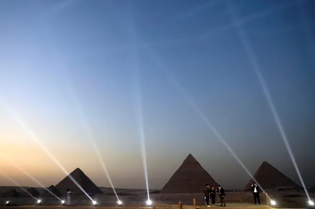 People take pictures in front of the Great Pyramids during the opening of a new restaurant called “9 Pyramids Lounge” by Orascom Pyramids Entertainment (OPE) in Giza, Egypt on October 20, 2020. (Photo by Amr Abdallah Dalsh/Reuters)