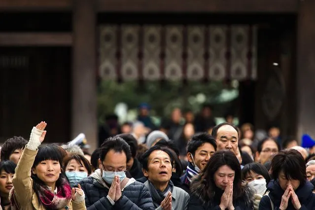 People pray and throw offerings for the upcoming year at the Shinto Meiji Shrine in Tokyo January 1, 2015. (Photo by Thomas Peter/Reuters)