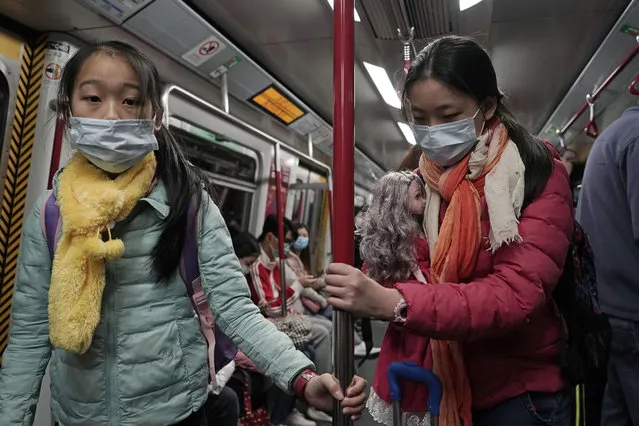 Two girls with face masks ride the subway in Hong Kong, Saturday, February 1, 2020. China’s death toll from a new virus has risen to 259 and a World Health Organization official says other governments need to prepare for“domestic outbreak control” if the disease spreads. (Photo by Kin Cheung/AP Photo)