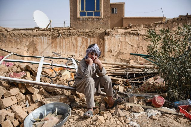 An Afghan earthquake survivor sits over the remains of a damaged house at a village in Tashqurghan, in the Khulm district of Samangan province on November 3, 2025. A 6.3-magnitude strong earthquake that struck overnight killed at least 20 people in northern Afghanistan, authorities said on November 3, just months after another deadly tremor that left the country reeling. (Photo by Atif Aryan/AFP Photo)