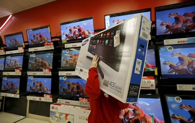 A worker carries a television for a customer who made a purchase during Black Friday Shopping at a Target store in Chicago, Illinois, United States, November 27, 2015. (Photo by Jim Young/Reuters)
