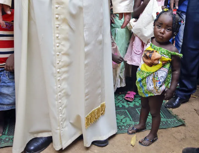 Children stand near Pope Francis during his visit at a refugee camp, in Bangui, Central African Republic, Sunday, November 29, 2015. The Pope has landed in the capital of Central African Republic, his final stop in Africa and where he will seek to heal a country wracked by conflict between Muslims and Christians. (Photo by Andrew Medichini/AP Photo)