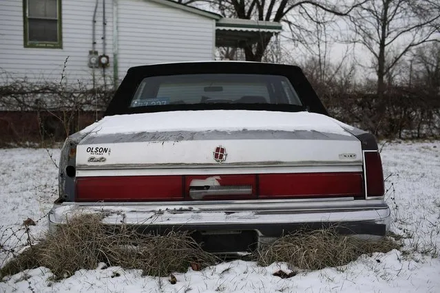 An older model Lincoln Town Car with body damaged  sits in a backyard of a home in Detroit, Michigan  January 8, 2015. (Photo by Joshua Lott/Reuters)