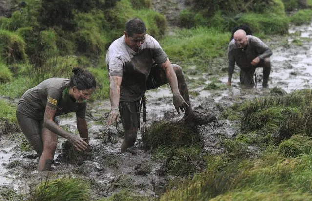 Competitors take part in the Christmas Really Wild Mud Run on a 4.6 miles course across undulating farm land at Celtic Camping, St David's, Pembrokeshire, Wales, December 12, 2015. (Photo by Rebecca Naden/Reuters)