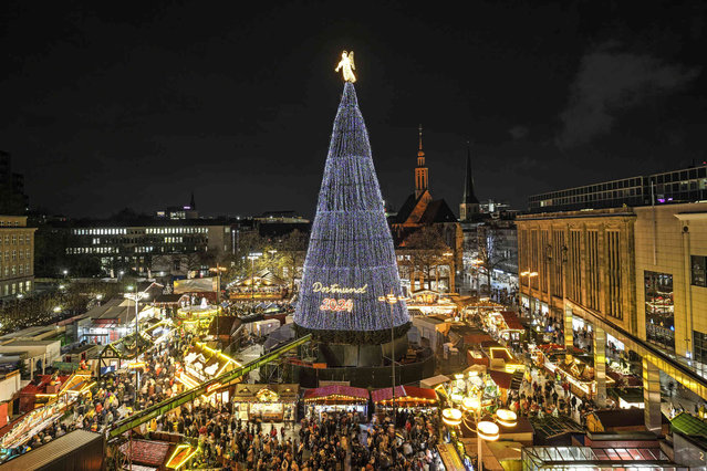 The traditional 45 meter high Dortmund Christmas tree, one of the world's largest, is illuminated for the first time this year at the Christmas market in Dortmund, Germany, Monday, November 25, 2024. (Photo by Martin Meissner/AP Photo)