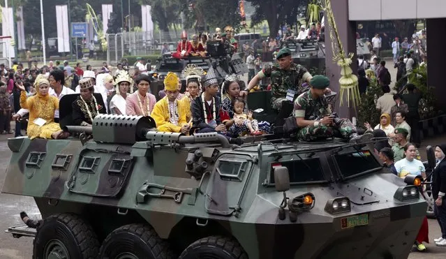 Brides and grooms sit on top of an Indonesian Army vehicle during a mass wedding ceremony organized in Jakarta, Indonesia, Wednesday, January 28, 2015. (Photo by Achmad Ibrahim/AP Photo)
