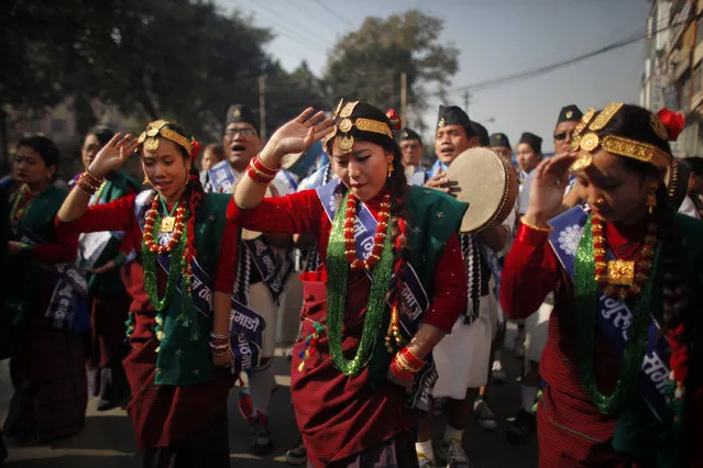Nepalese Gurung community men and women wear traditional attire as they dance at a parade to mark their New Year known as “Tamu Loshar” in Kathmandu, Nepal, Wednesday, December 30, 2015. The indigenous Gurungs, also known as Tamu, are celebrating the advent of the year of the monkey. (Photo by Niranjan Shrestha/AP Photo)