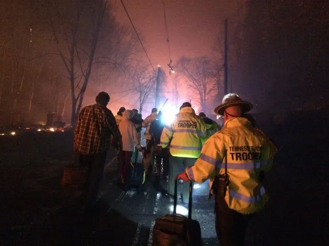 Troopers from the Tennessee Highway Patrol help residents leave an area under threat of wildfire after a mandatory evacuation was ordered in Gatlinburg, Tennessee in a picture released November 30, 2016. (Photo by Reuters/Tennessee Highway Patrol)