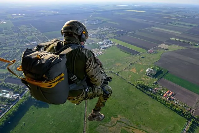 A paratrooper of the Hungarian Army’s 24th Gergely Bornemissza Scout Regiment leaps from an aircraft during the regiment's drill at the airport of Hajduszoboszlo, Hungary, 11 May 2022 (issued 12 May 2022). The paratroopers made their jumps from heights between 500 and 3,000 meters as a tribute to late Staff Sergeant Szabolcs Gal, a member of the Hungarian Armed Forces world champion parachute team, of the 86th Szolnok Helicopter Base. The 32-year-old Gal suffered a parachute accident at the end of April after which he was hospitalized ever since but died on the morning of 11 May. (Photo by Zsolt Czegledi/EPA/EFE)