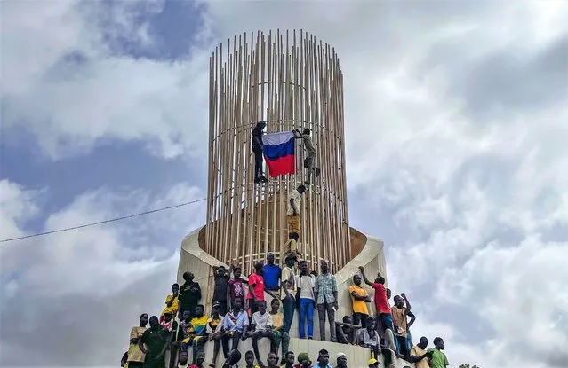 Supporters of Niger's ruling junta hold a Russian flag at the start of a protest called to fight for the country's freedom and push back against foreign interference in Niamey, Niger, Thursday, August 3, 2023. The march falls on the West African nation's independence day from its former colonial ruler, France, and as anti-French sentiment spikes, more than one week after mutinous soldiers ousted the country's democratically elected president. (Photo by Sam Mednick/AP Photo)