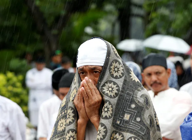 Indonesian Muslims prepare for Friday prayers in the rain near the National Monument, also known as Monas, during a rally calling for the arrest of Jakarta's Governor Basuki Tjahaja Purnama, popularly known as Ahok, who is accused of insulting the Koran, in Jakarta, Indonesia December 2, 2016. (Photo by Darren Whiteside/Reuters)