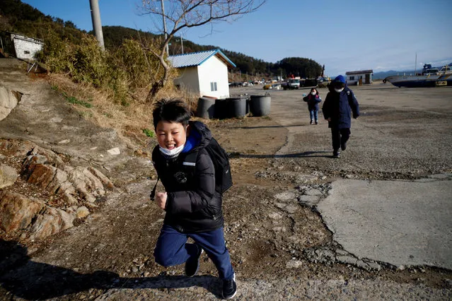 Lyoo Chan-hee, 10, Lyoo Chae-hee, 7, and Kim Si-hu, 9, make their way to school on the first day of the new semester, on Nokdo island in Boryeong, South Korea, March 2, 2021. Lyoo Chan-hee wishes he wasn't one of the last three schoolkids left playing on the beaches of Nokdo island. Instead, he often plays with Kim Si-young - aged 66, and one of the last 100 or so residents of a once-vibrant fishing village emblematic of the demographic crisis unfolding in South Korea. (Photo by Kim Hong-Ji/Reuters)