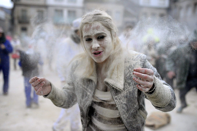 A woman covered in a mixture of flour and bran (“farelos”) takes part at the “Domingo Fareleiro” at Xinzo de Limia town, Ourense province, Galicia region, north-western Spain, 17 January 2016. As a purification ritual, the “Domingo Fareleiro” is a real battle of flour that takes place every year in the town, in a unique celebration that has the flour as its main protagonist, and gives the starting signal for a long festive period named “Entroido” (“Carnival” in Galician). (Photo by Brais Lorenzo/EPA)